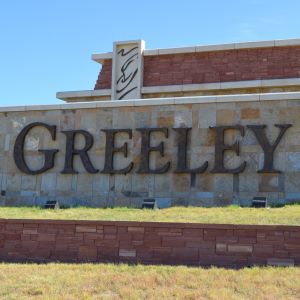 A large stone and brick welcome sign displaying 